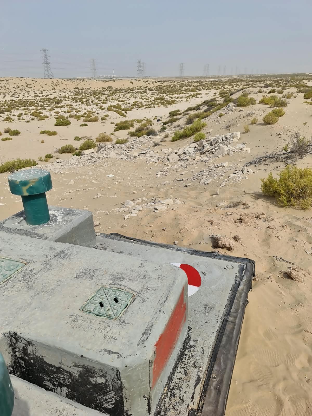 Survey benchmark monument near Dubai power transmission lines